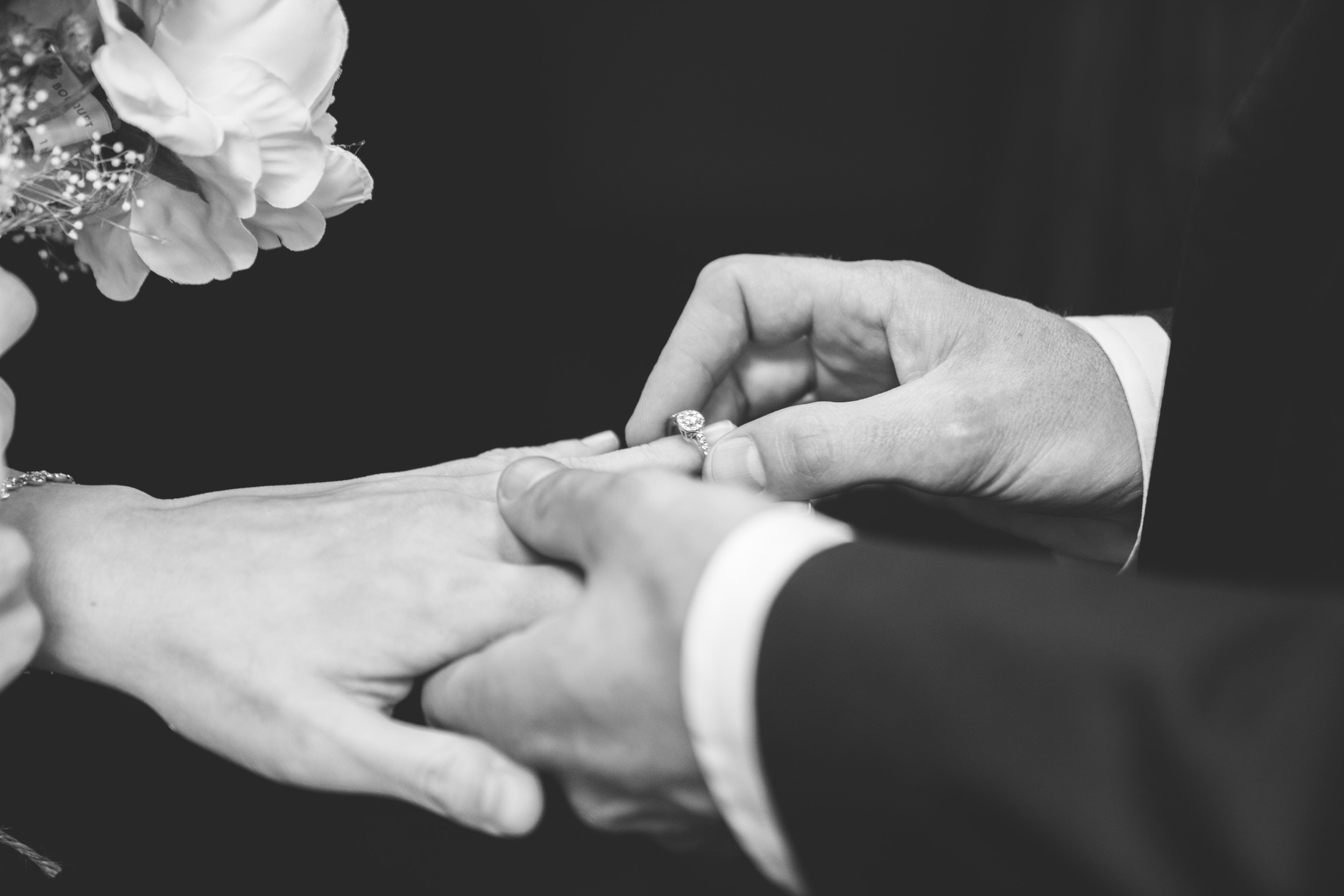 groom placing ring on bride's finger on wedding day in New Orleans French Quarter