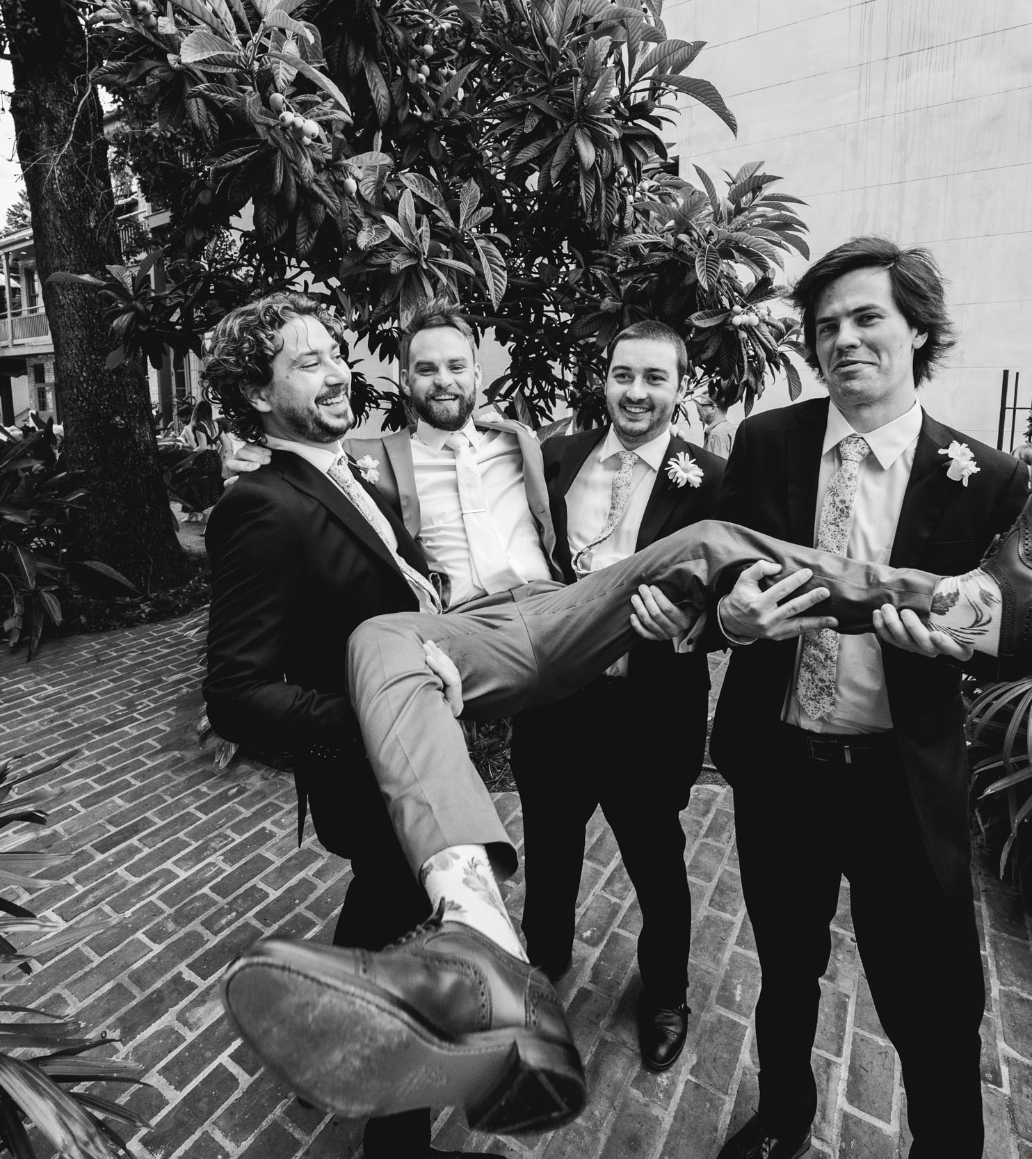 groomsmen carrying groom and laughing on wedding day at Margaret Place in New Orleans