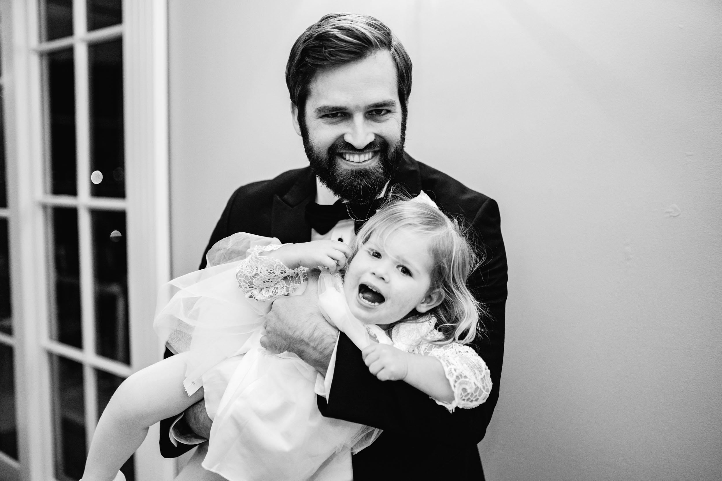 wedding guest holding and laughing with flower girl during wedding reception at at the Riverview Room in New Orleans