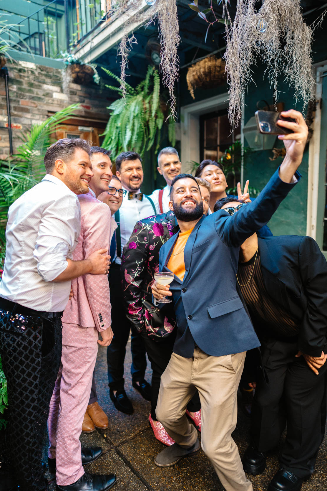 wedding guests taking a selfie on their phone with gay wedding couple at the Historic Swoop Duggins House in New Orleans