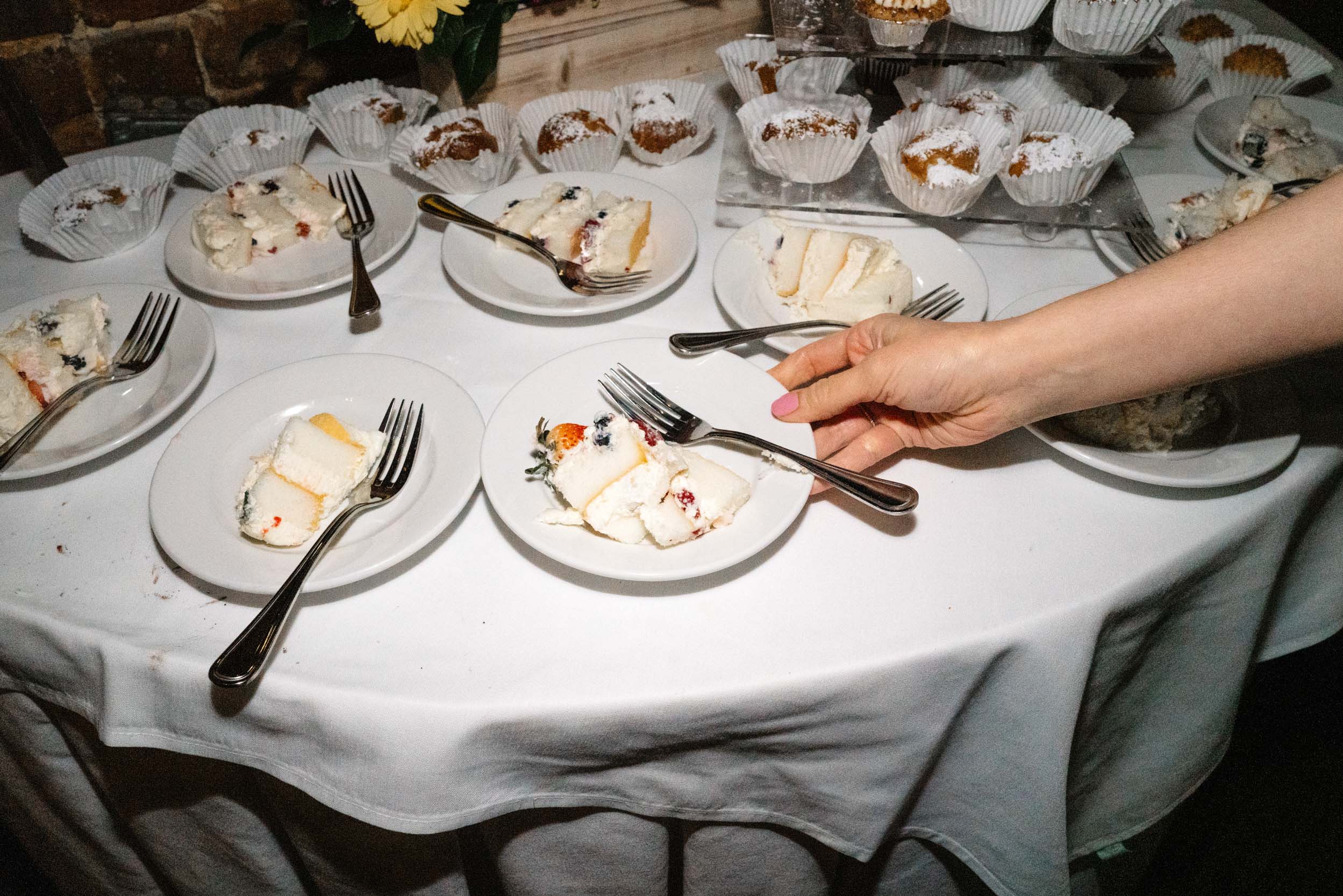 woman taking a slice of wedding cake during wedding reception at Rosy’s Jazz Hall in New Orleans