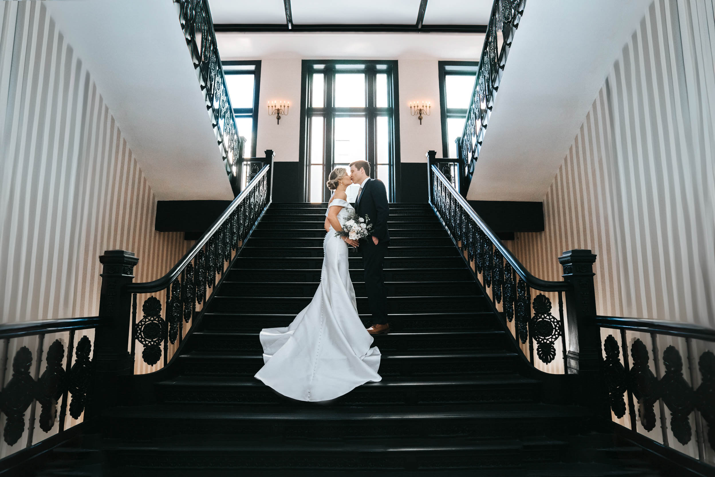 Bride and Groom kissing on antique staircase at the Maison De La Luz Hotel in New Orleans