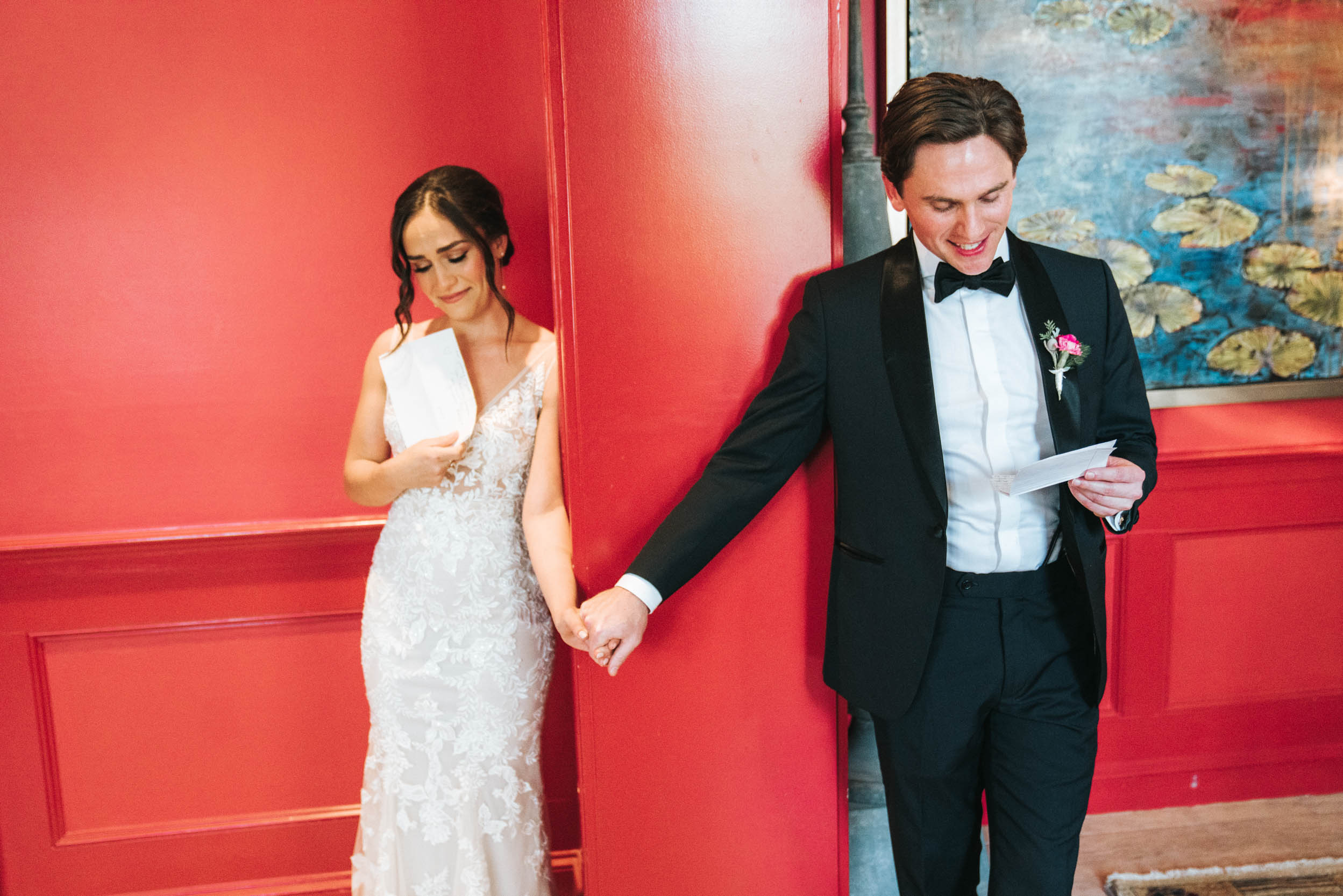 bride and groom holding their hands while reading letters to each other during first look (first touch) on wedding day at the Southern Hotel in Covington, Louisiana