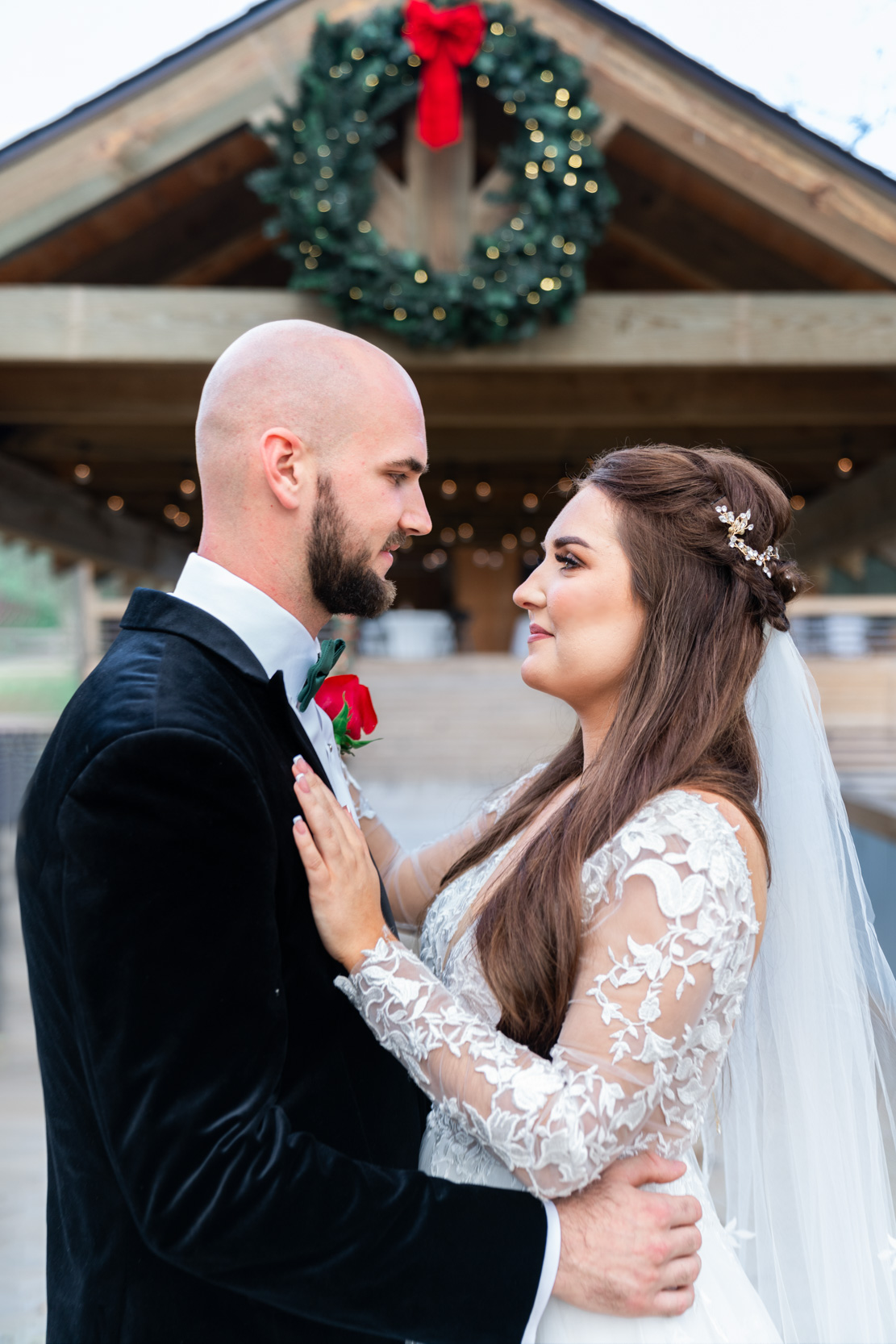 bride and groom looking at each other on wedding day with Christmas theme at Creekview Barn in Mississippi