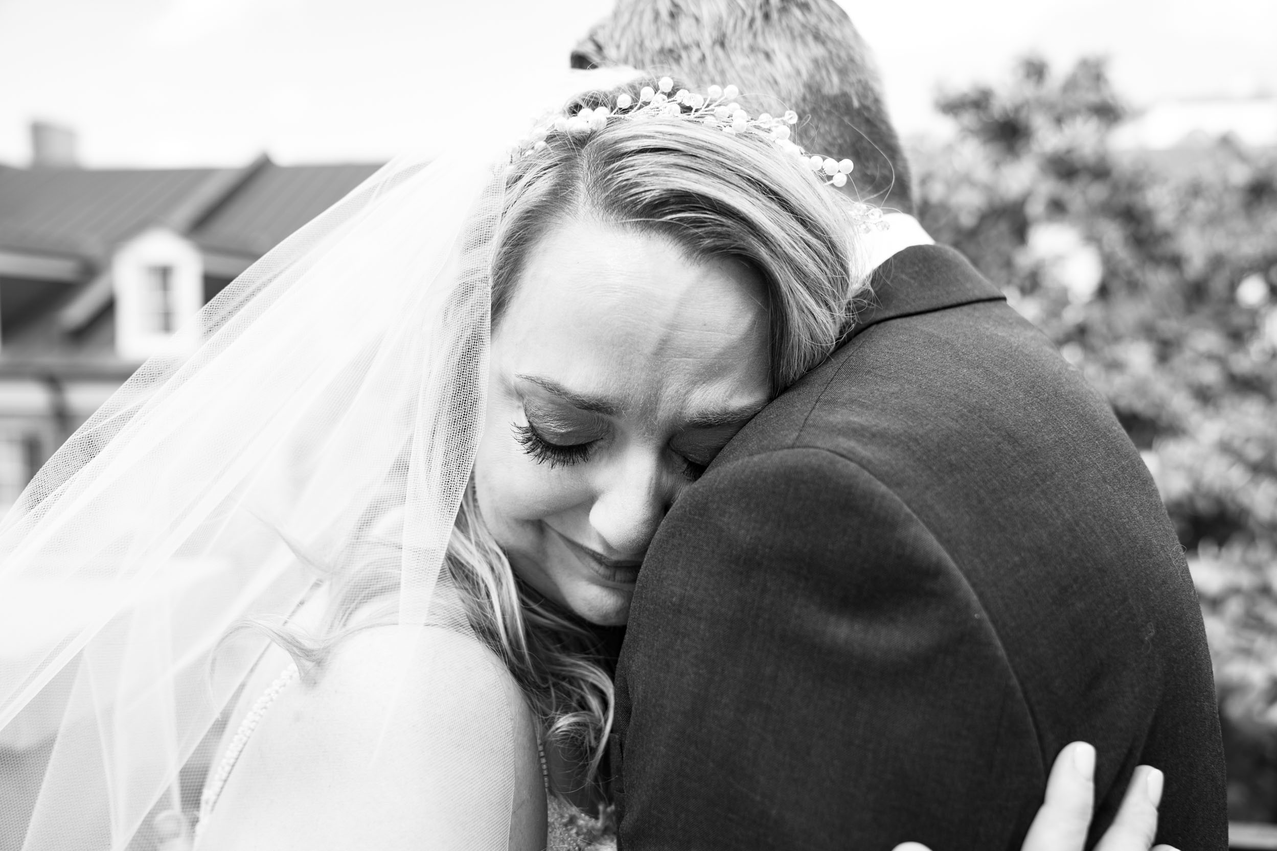 bride crying and hugging groom during first look on balcony at Hotel Mazarin in The French Quarter of New Orleans