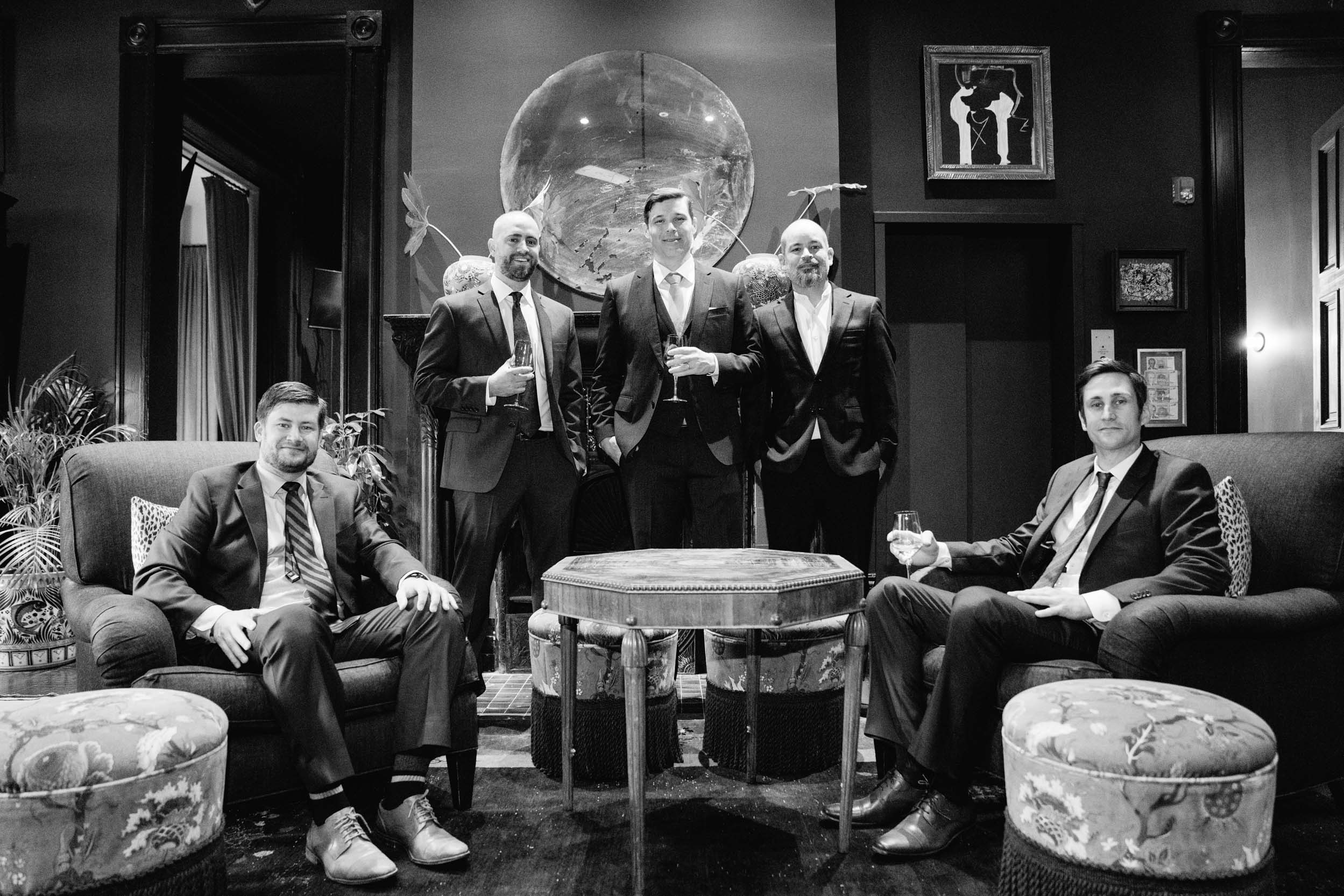 groom and his groomsmen posing in the dining room of the Hotel Chloe in New Orleans