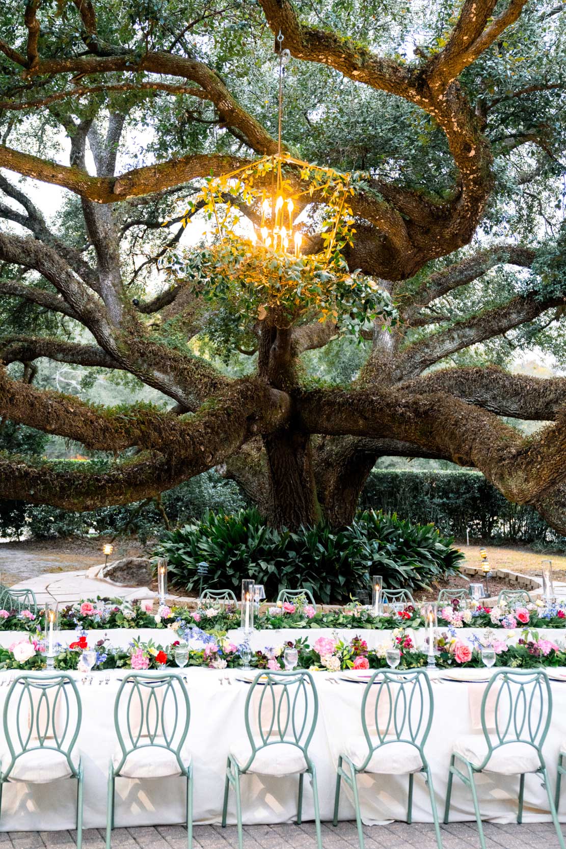 table decor and flowers by Petals and Parties flowers on wedding day under large oak tree at at The Greenwood Covington, Louisiana