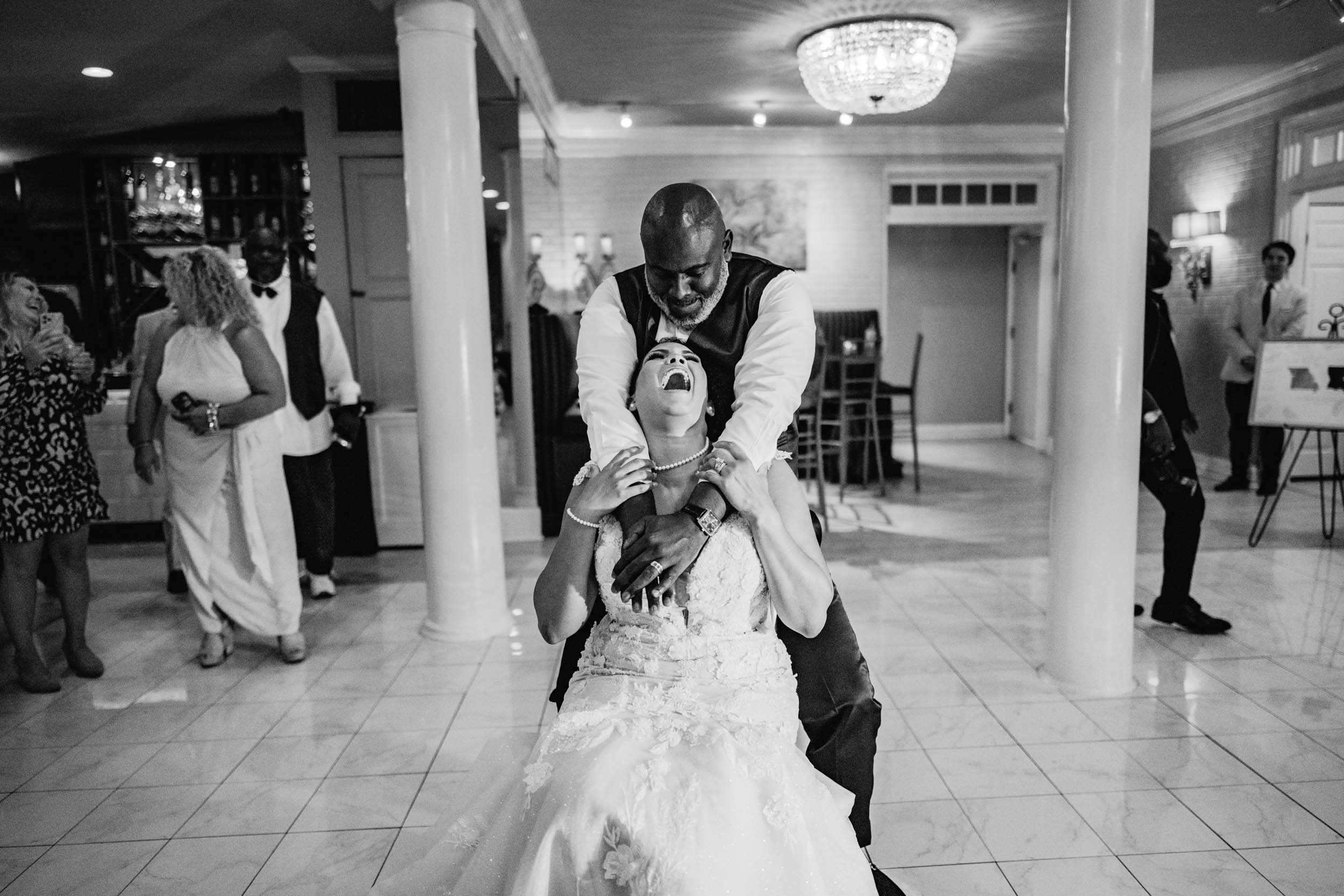 African American bride and groom laughing during the garter toss at Southern Oaks in New Orleans