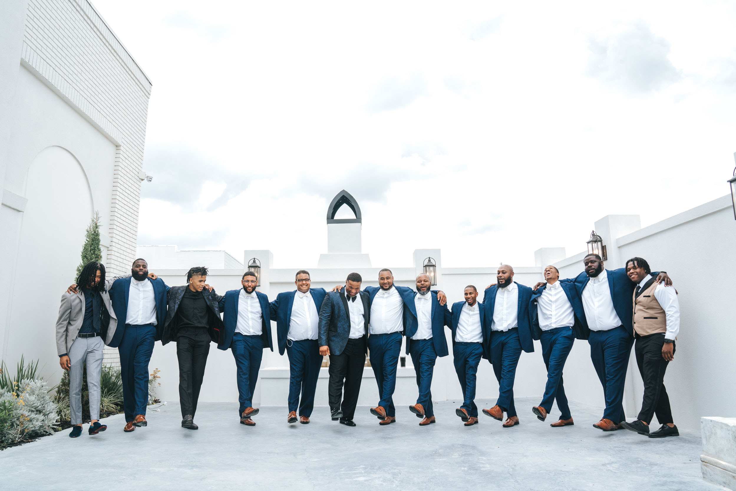 African American groom and groomsmen dancing together in their blue suits on wedding day at The Moore in Harahan, Louisiana