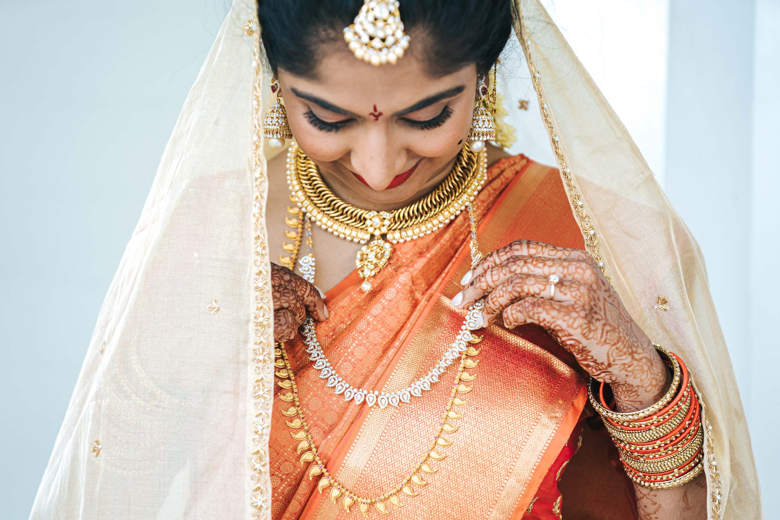 American Indian bride adjusting her jewerly before nikah ceremony at Derbès Mansion in New Orleans