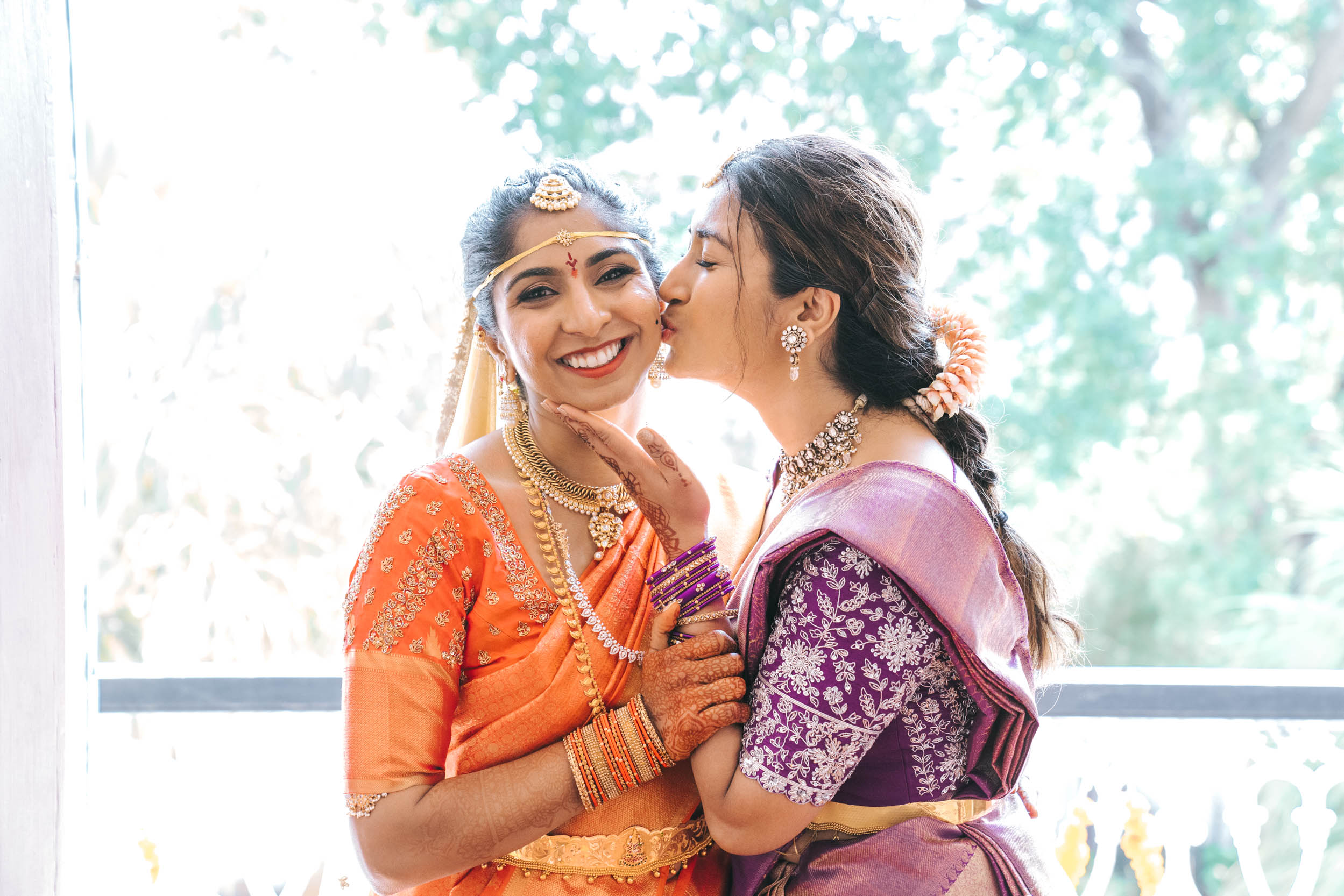 American Indian bride hugging her family member wearing lehenga or a saree wedding dress at Derbès Mansion in New Orleans