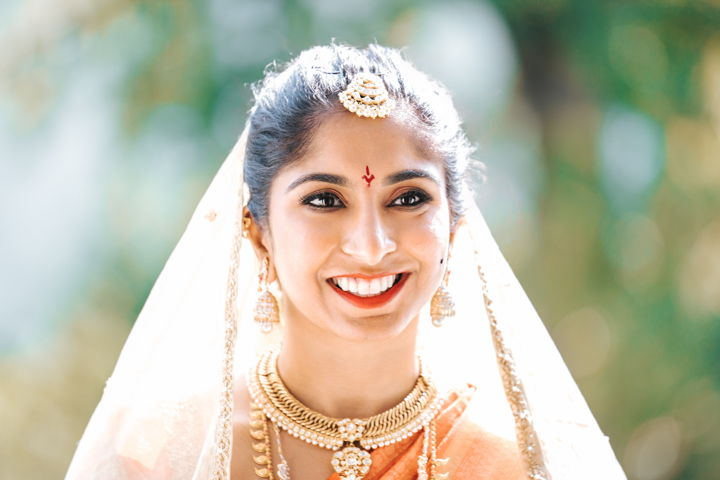 American Indian bride smiling on sunny day Hindu wedding at Derbès Mansion in New Orleans