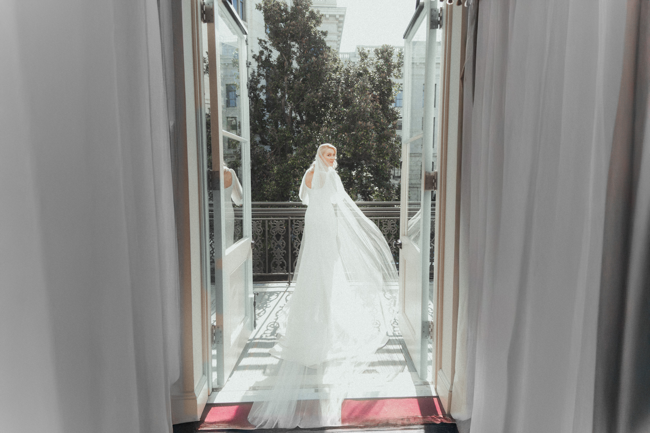 Bride on balcony in the French Quarter turning back with veil