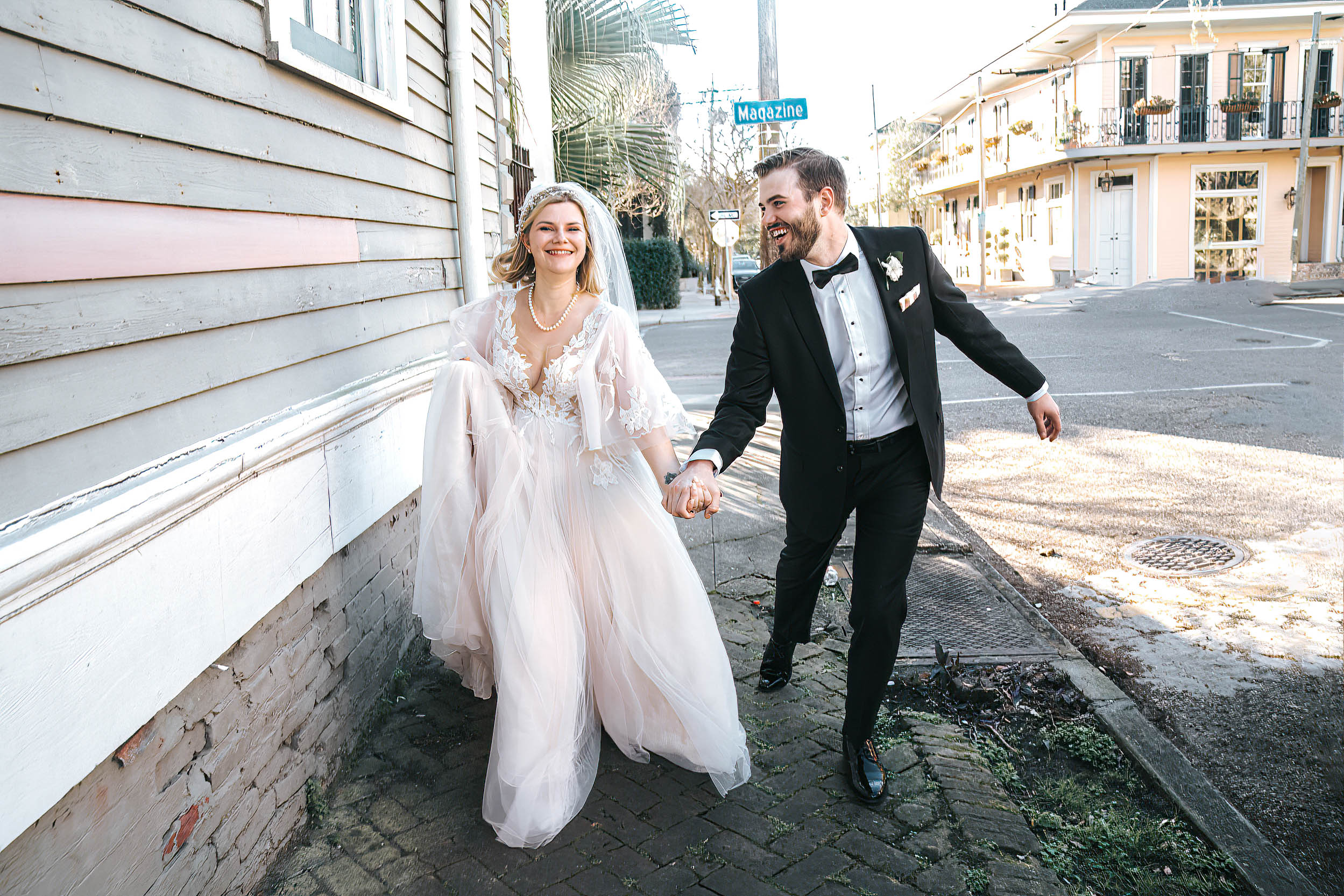 bride and groom running on sidewalk in New Orleans on wedding day in Lower Garden District