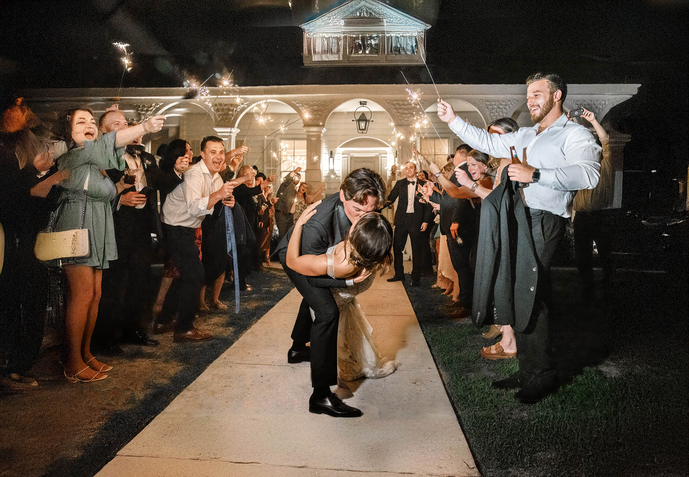 Groom dipping bride and kissing her during celebration exit at Maison Lafitte in Covington, Louisiana