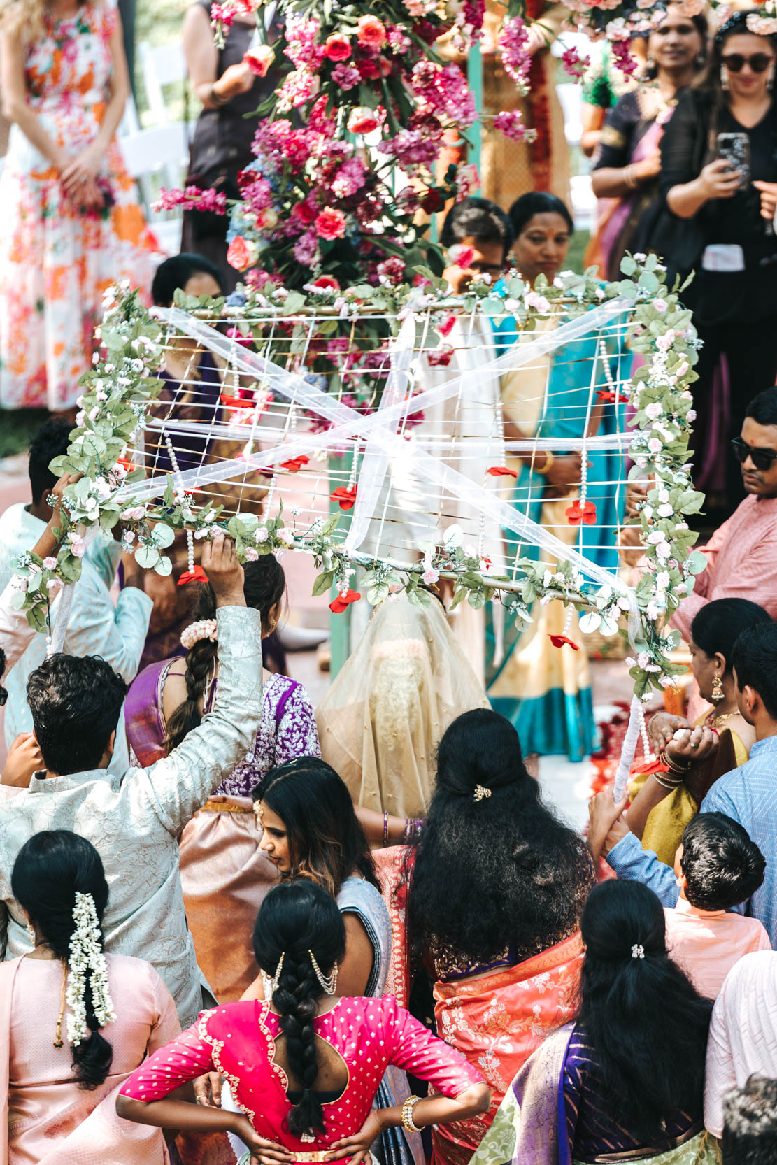 Islamic or Hindu American bride entering nikah ceremony surrounded by wedding guests at Derbès Mansion in New Orleans