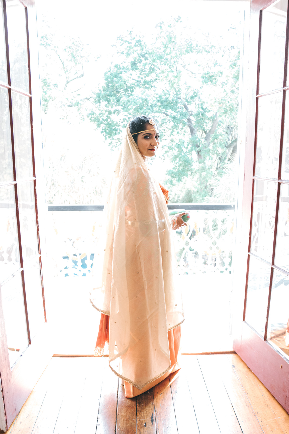 Islamic or Hindu American bride posing on balcony at Derbès Mansion in New Orleans