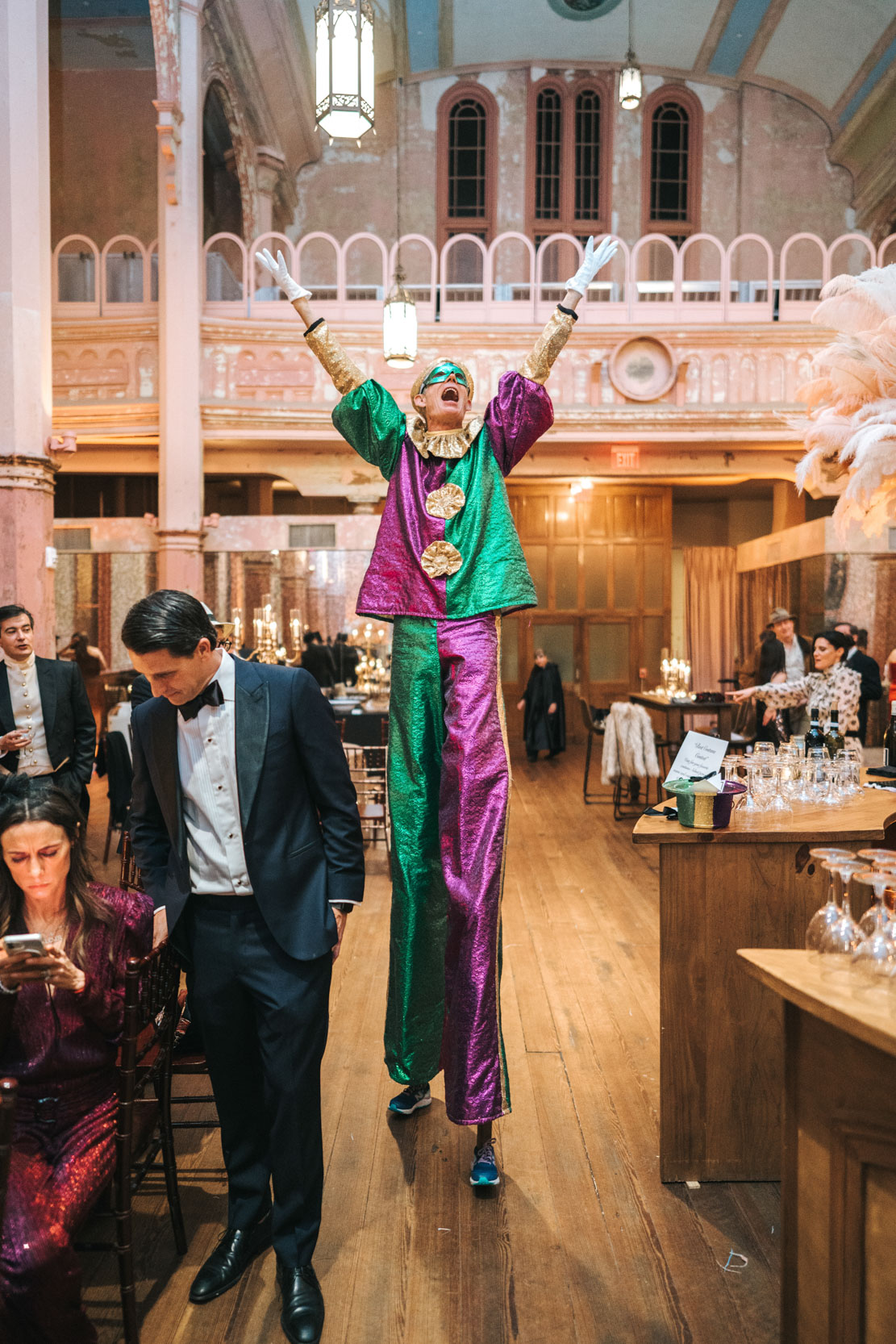 Mardi Gras stilt walker entertaining guests during wedding reception at Hotel Peter and Paul in New Orleans Bywater