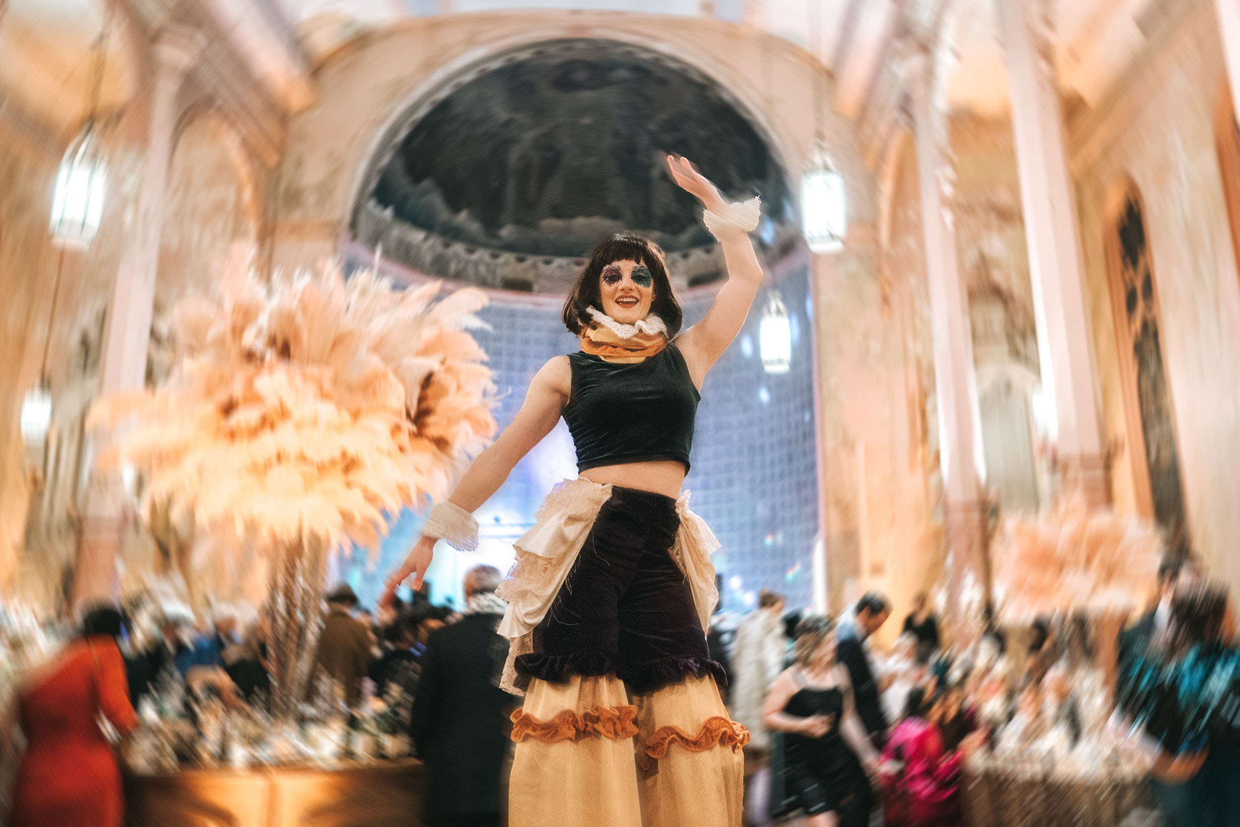 Stilt walker entertaining guests during masquerade wedding reception at Hotel Peter and Paul in New Orleans Bywater-Edit