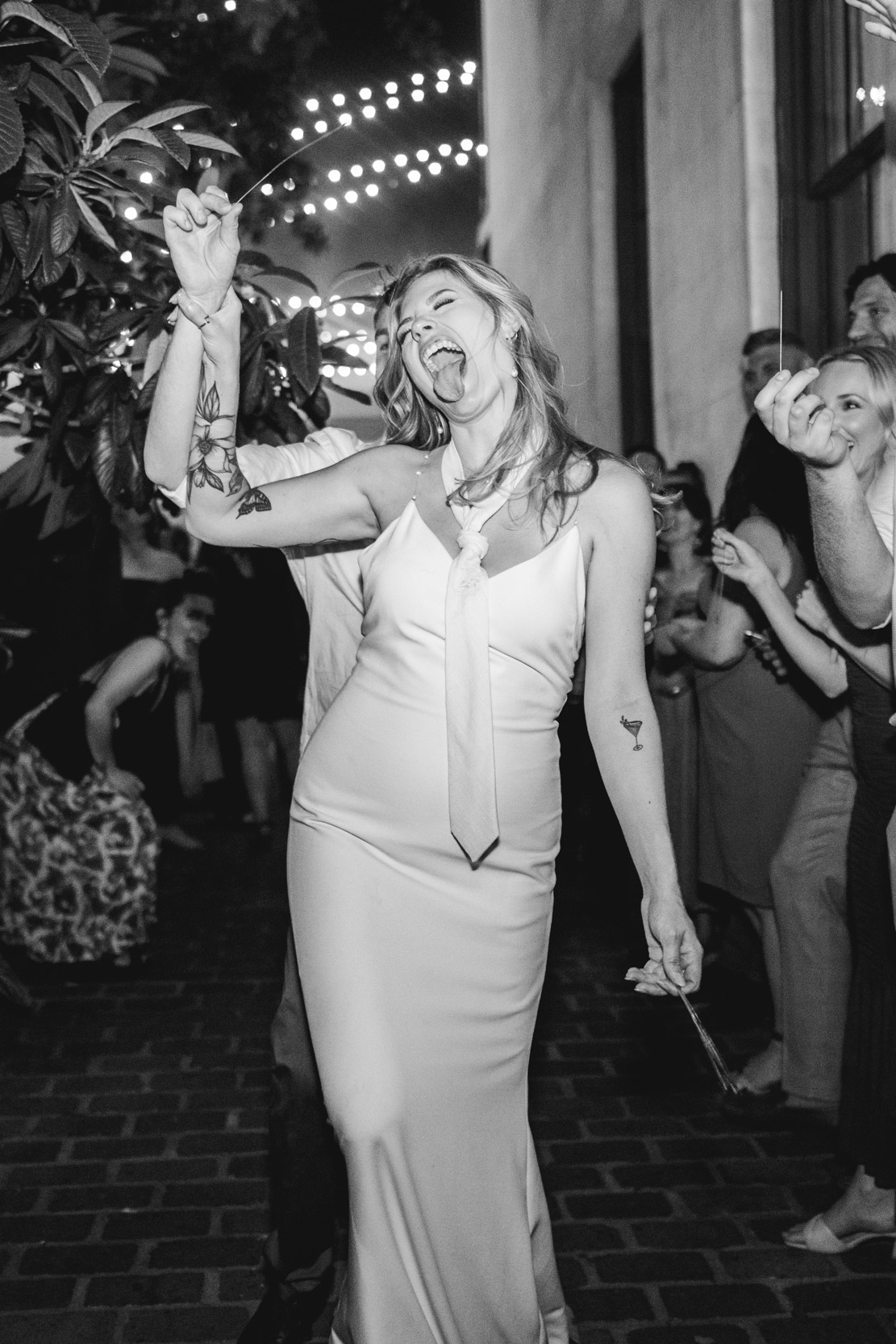 flash photo of bride sticking her tongue out during sparkler exit on wedding day at at Margaret Place in New Orleans