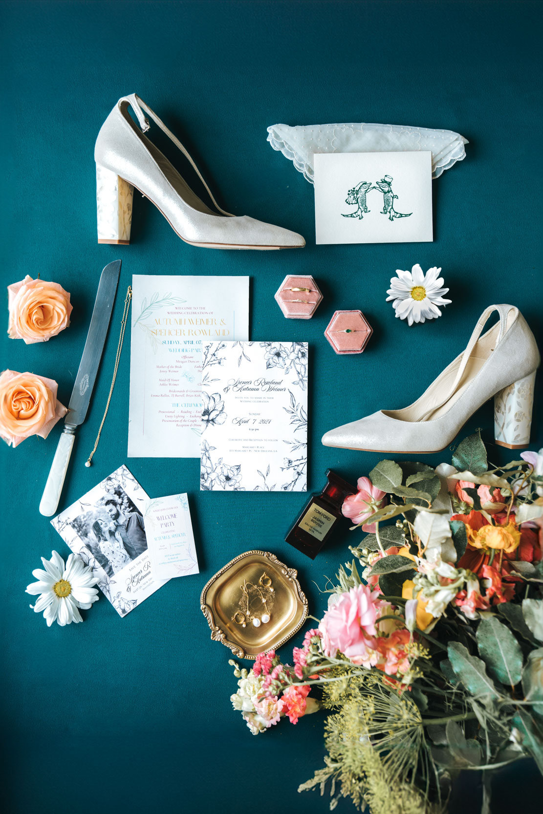 flat lay with Freya Rose bridal shoes, Cicada Calling flowers, Tom Ford perfume, Hotel Chloe invitation, Oore rings, roses, and daisies at Margaret Place in New Orleans