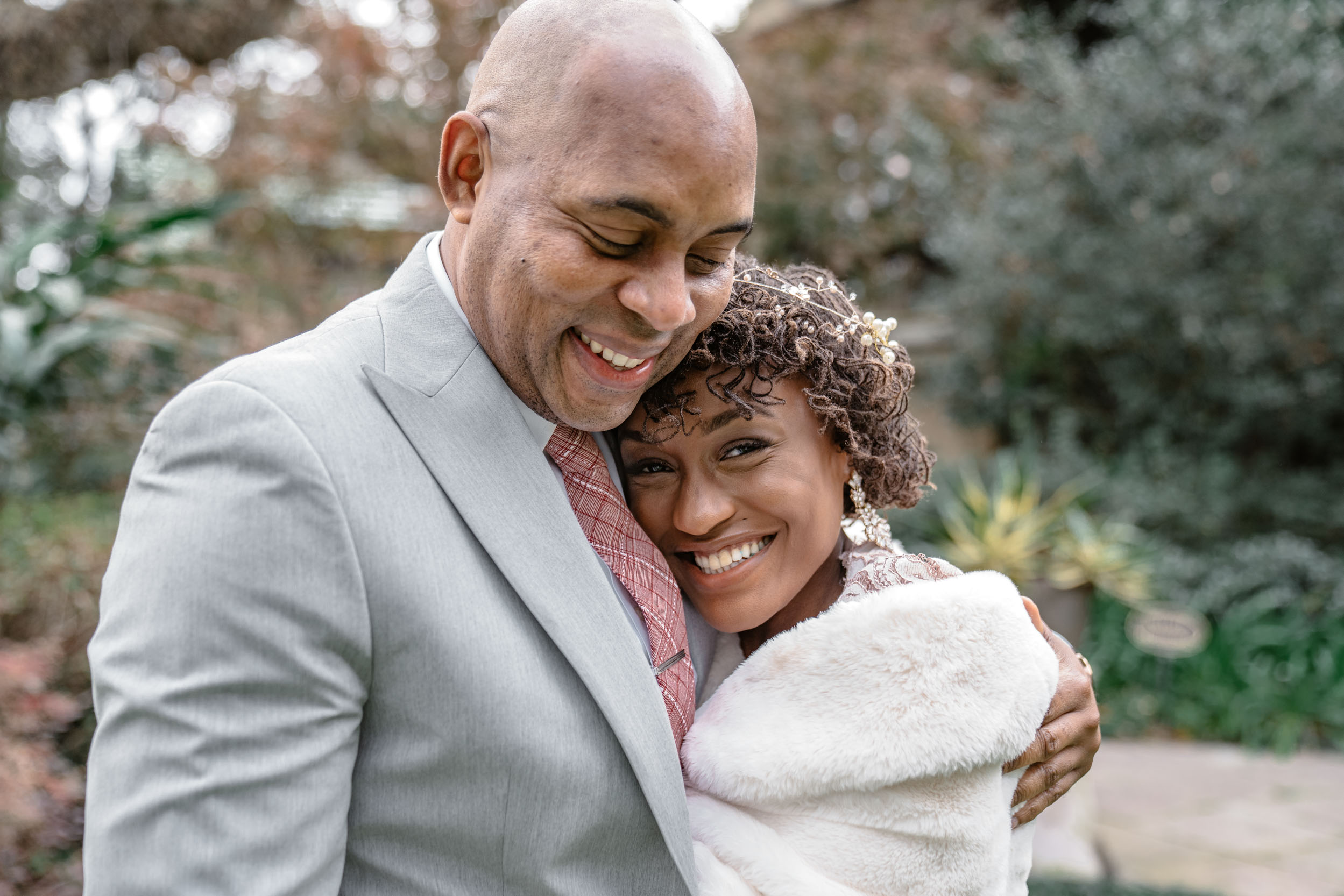 happy African American couple hugging on wedding day in Audubon Park in New Orleans