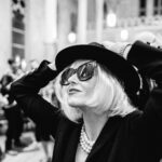 woman in all black with black glasses and black hat during masquerade wedding reception at Hotel Peter and Paul in New Orleans Bywater